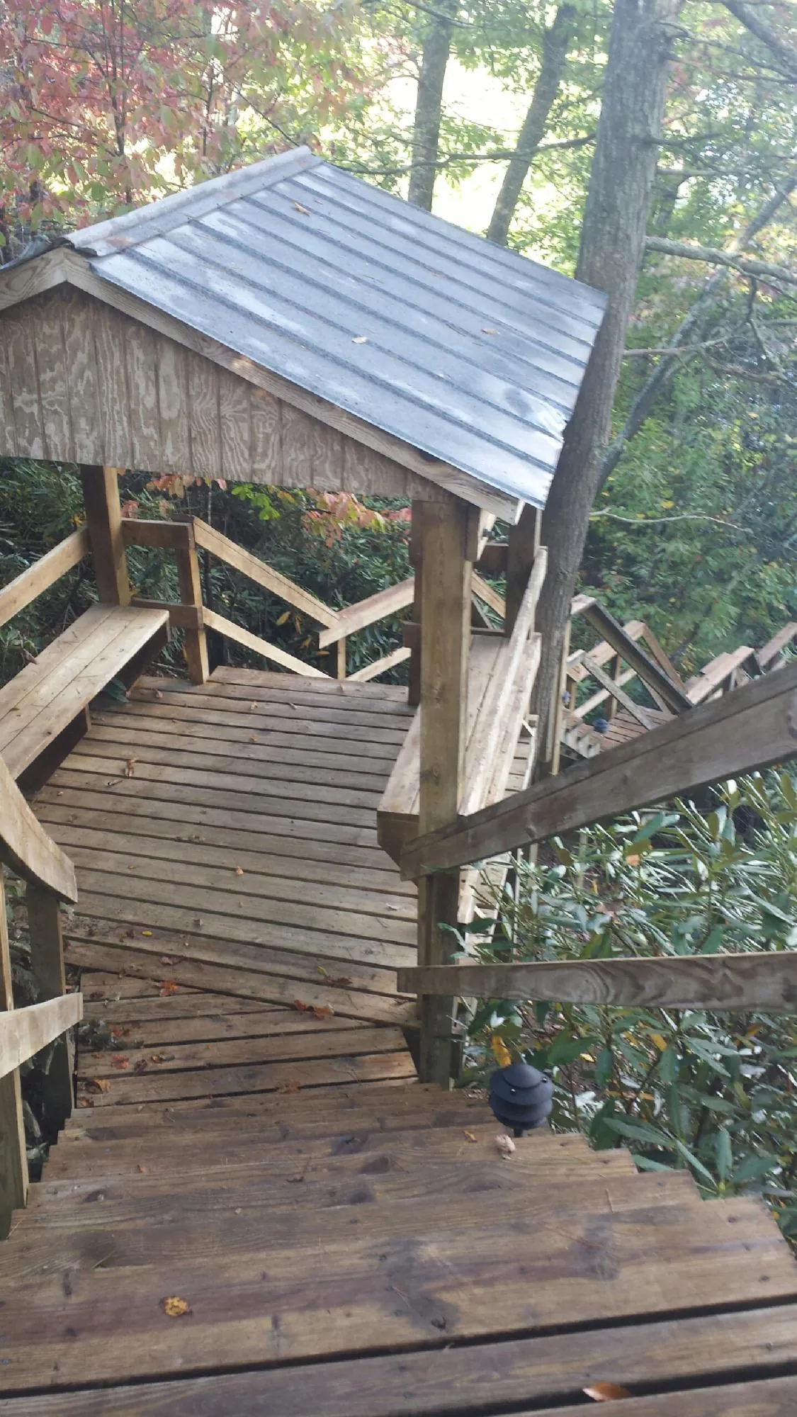 Metal roofed shelter over wooden steps on a wooded walkway — Skylight Repair & Installation work by our crew in Quincy